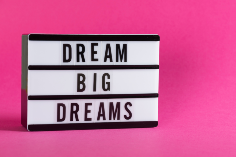 bright pink background with a sign that says dream big dreams